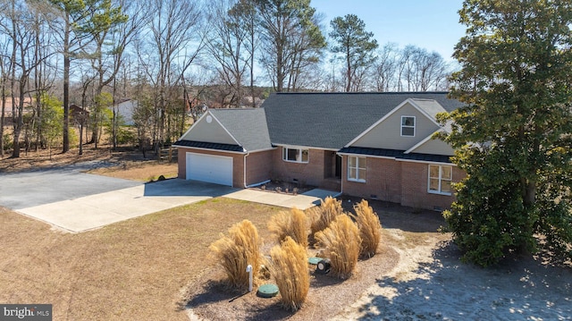 view of front facade with concrete driveway, an attached garage, a shingled roof, crawl space, and brick siding