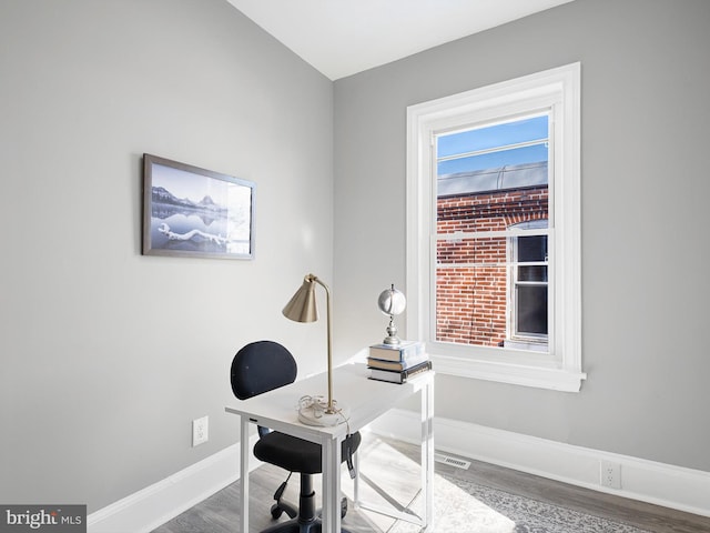 office space featuring visible vents, baseboards, and wood finished floors