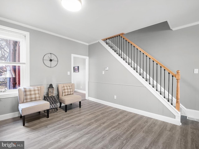 living area featuring crown molding, stairway, plenty of natural light, and wood finished floors