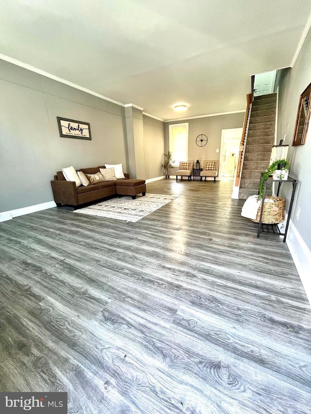 unfurnished living room featuring crown molding, stairs, baseboards, and wood finished floors