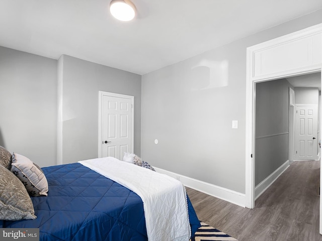 bedroom with baseboards and dark wood finished floors