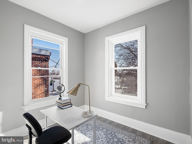 home office with plenty of natural light, wood finished floors, and baseboards