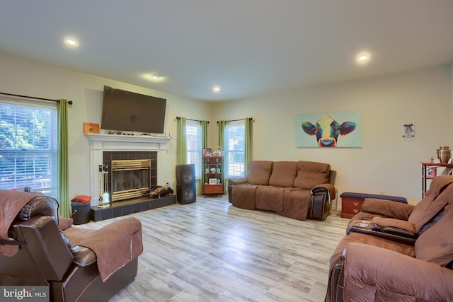 living room featuring a fireplace, recessed lighting, and wood finished floors