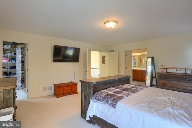 bedroom featuring visible vents, connected bathroom, a closet, carpet flooring, and a spacious closet