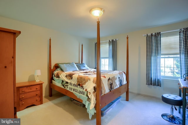 carpeted bedroom featuring multiple windows and baseboards