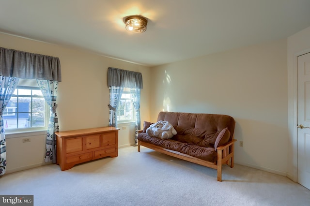 living area with baseboards and light carpet