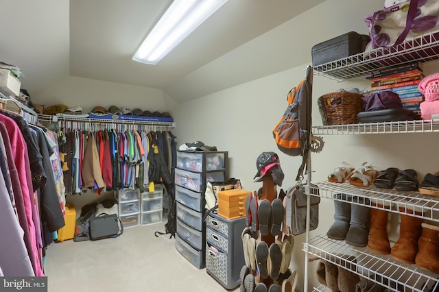 walk in closet with lofted ceiling and carpet flooring