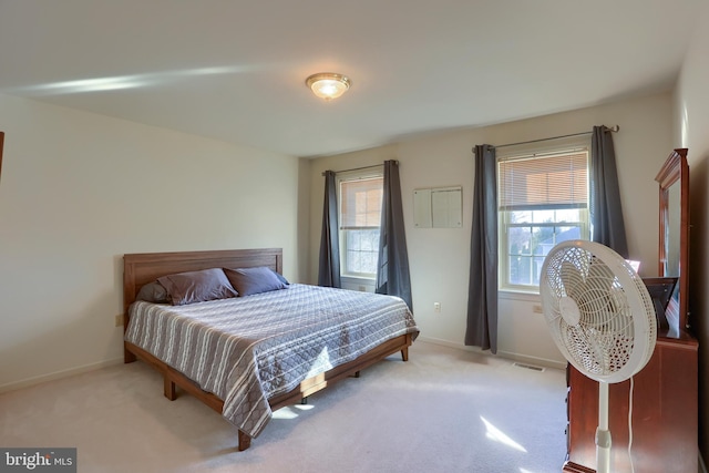 bedroom featuring light colored carpet, visible vents, and baseboards