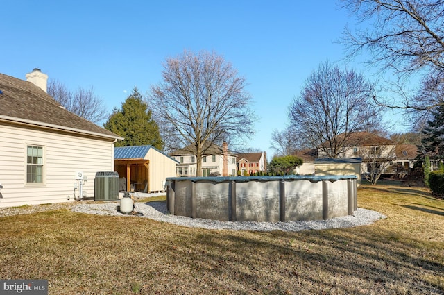 view of yard featuring a covered pool and central air condition unit