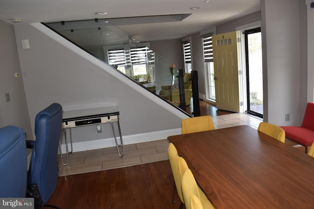 interior space featuring wood finished floors, plenty of natural light, a ceiling fan, and baseboards