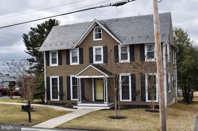 colonial home featuring a high end roof and a front yard