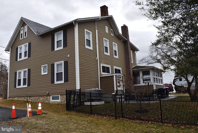 view of home's exterior with fence and a chimney