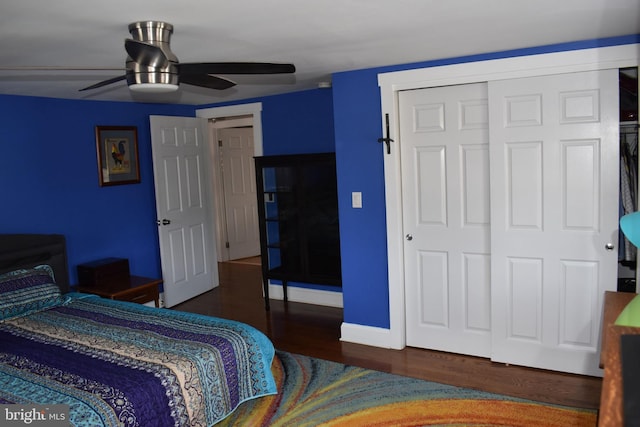 bedroom with wood finished floors, ceiling fan, baseboards, and a closet