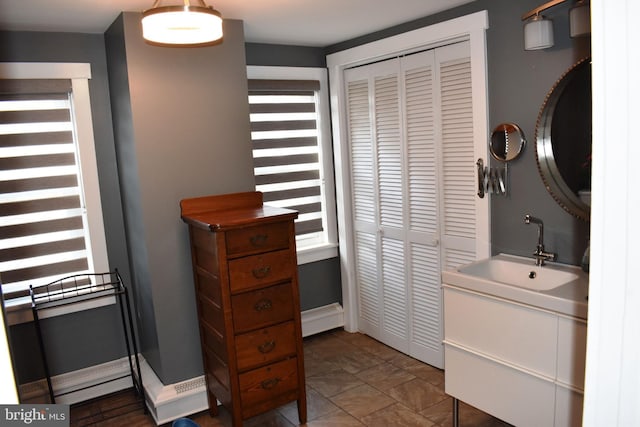 bathroom with baseboards, a closet, and vanity