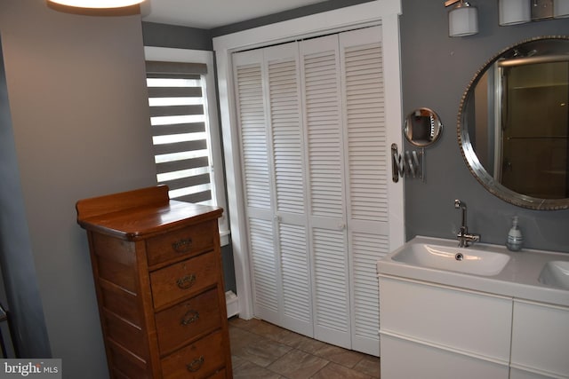 bathroom featuring tile patterned flooring, a closet, and vanity