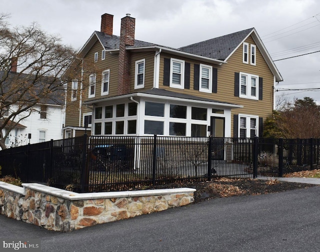 view of front of home with a fenced front yard and a chimney