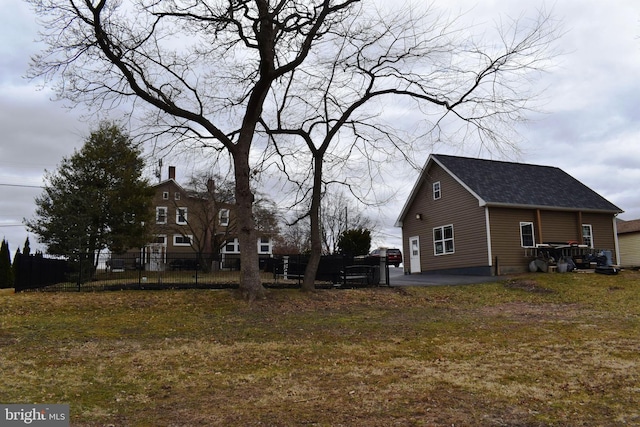 view of property exterior with a patio area, fence, and a shingled roof