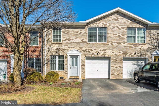 view of front facade with brick siding, an attached garage, and driveway