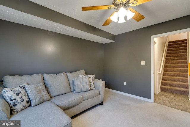 carpeted living area with stairway, baseboards, and ceiling fan