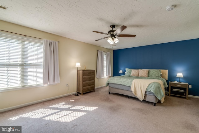 bedroom featuring baseboards, ceiling fan, a textured ceiling, and carpet