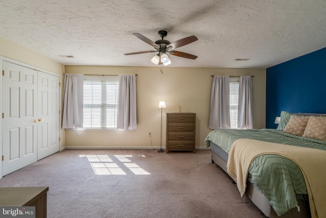 bedroom featuring visible vents, baseboards, carpet floors, a textured ceiling, and a ceiling fan