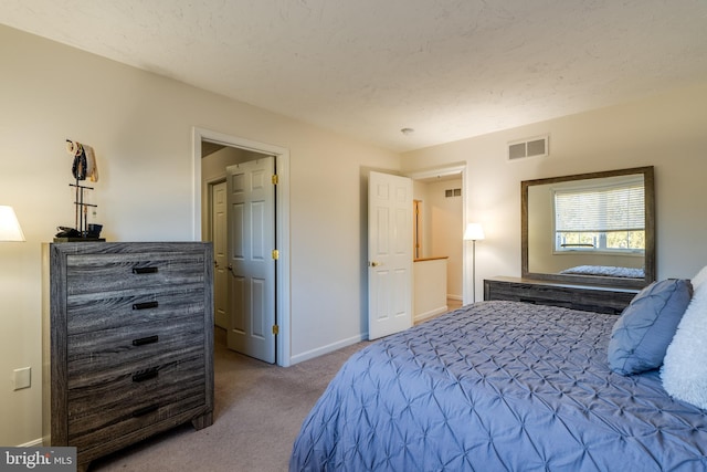 bedroom featuring visible vents, a textured ceiling, baseboards, and carpet