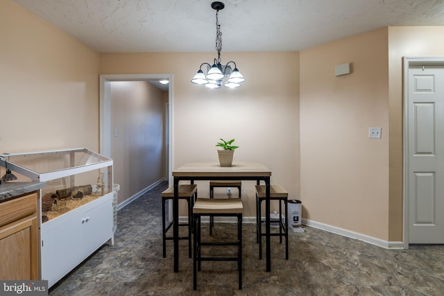 dining room with stone finish flooring, baseboards, and a notable chandelier