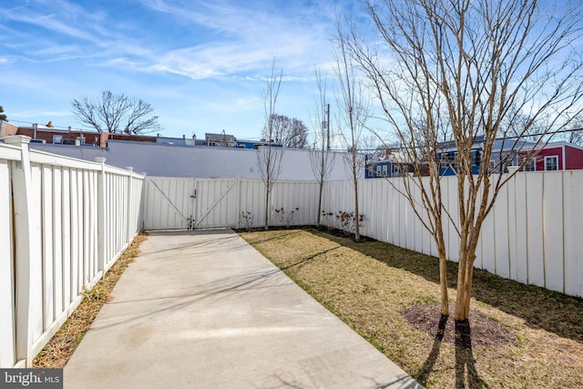 view of yard featuring a fenced backyard and a gate