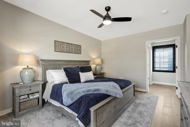 bedroom with a ceiling fan, light wood-type flooring, and baseboards