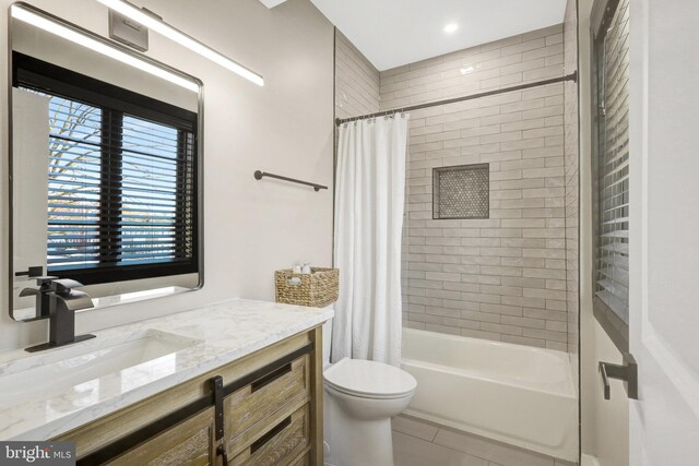 full bath featuring tile patterned floors, toilet, vanity, and shower / bath combination with curtain