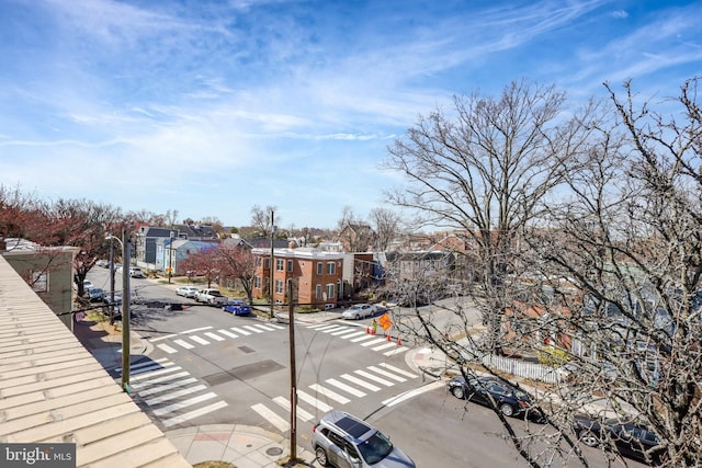 view of road with a residential view, curbs, street lights, and sidewalks