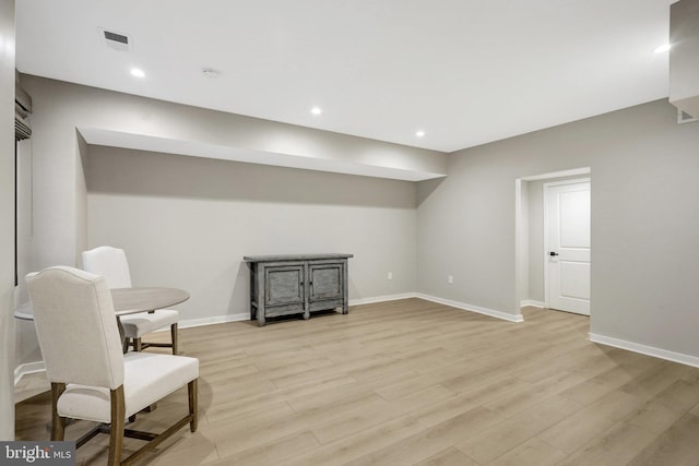 living area with visible vents, baseboards, and light wood-style flooring