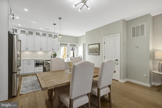 dining space with recessed lighting, visible vents, baseboards, and wood finished floors