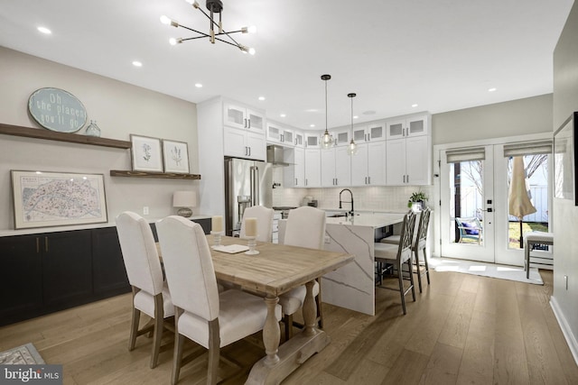 dining room with recessed lighting, french doors, light wood-style floors, and a chandelier