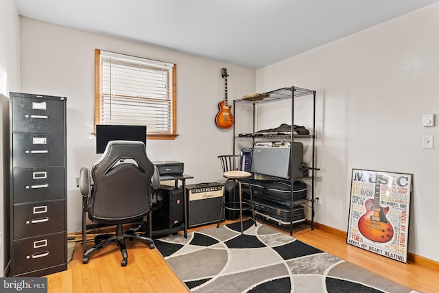 home office with baseboards and wood finished floors