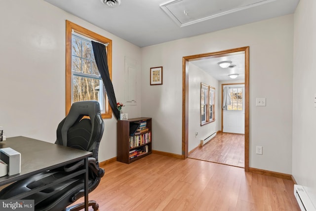 office featuring visible vents, baseboards, baseboard heating, and light wood finished floors