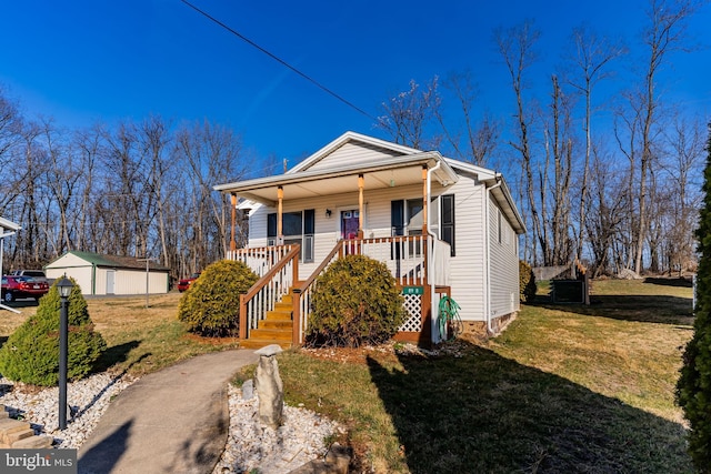 bungalow with stairs, a porch, a front lawn, and an outdoor structure