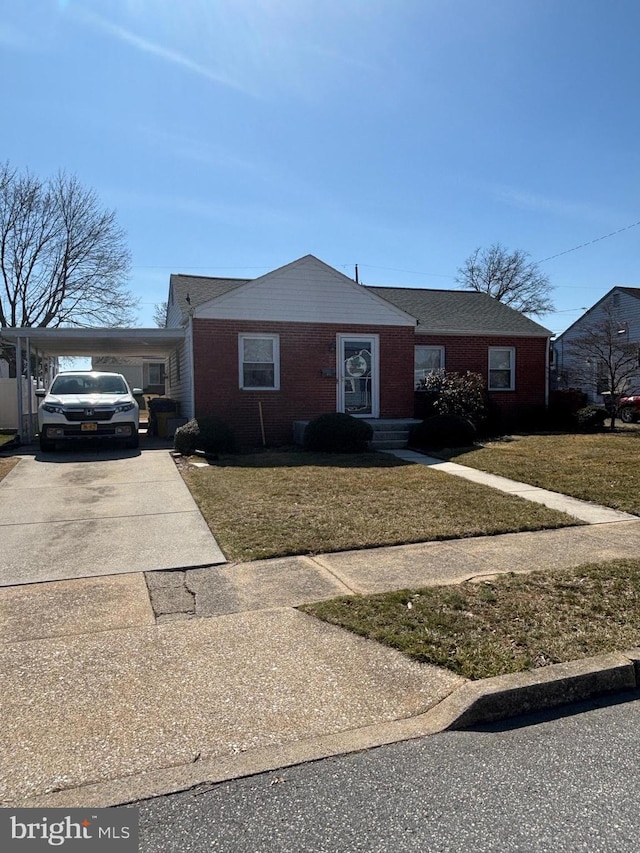 view of front of property with brick siding, concrete driveway, and a front lawn