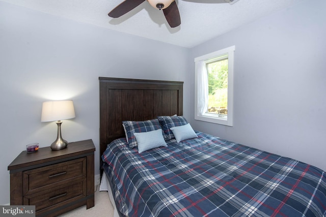 bedroom with light colored carpet and a ceiling fan