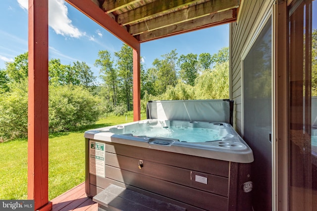 wooden terrace with a yard and a hot tub