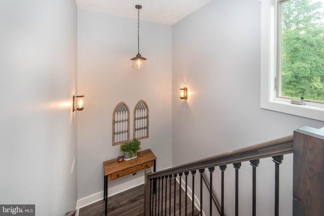 staircase featuring wood finished floors and baseboards