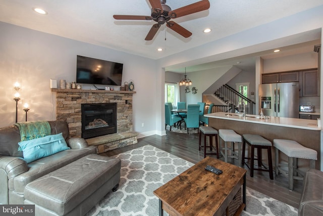 living area with stairs, recessed lighting, and dark wood-style flooring