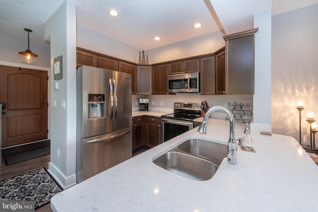 kitchen featuring pendant lighting, a sink, recessed lighting, stainless steel appliances, and dark brown cabinets