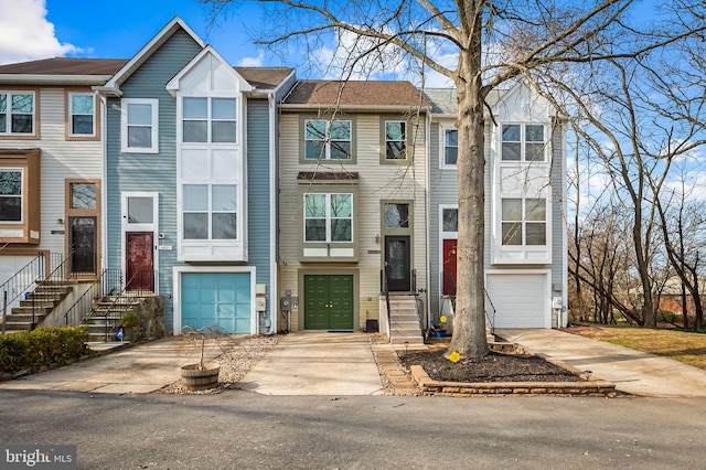 multi unit property featuring concrete driveway and an attached garage