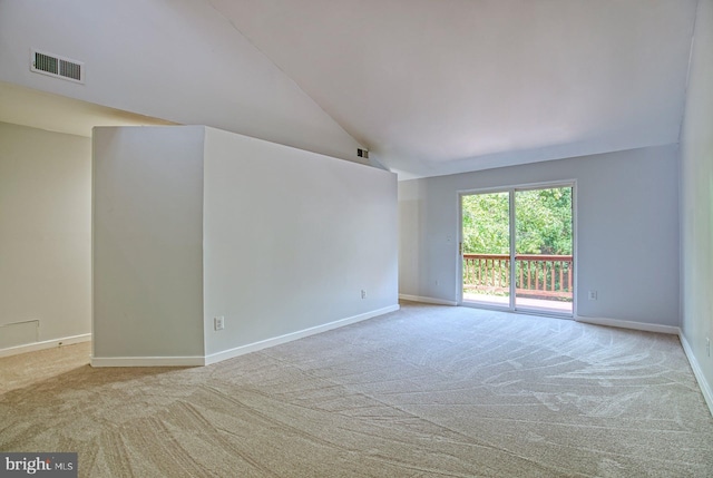 carpeted spare room with vaulted ceiling, baseboards, and visible vents