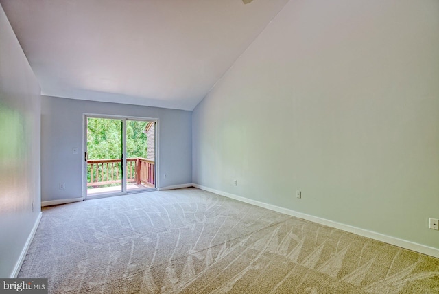 unfurnished room featuring baseboards, lofted ceiling, and carpet flooring