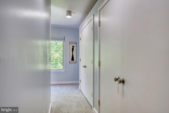 corridor with light colored carpet and baseboards