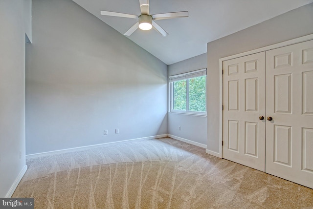 unfurnished bedroom with baseboards, lofted ceiling, and carpet