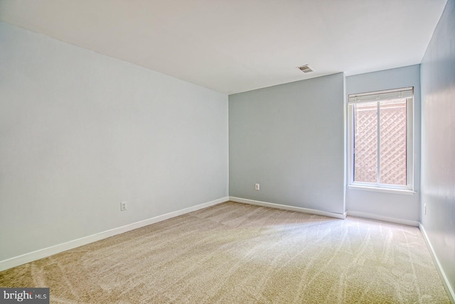 empty room featuring baseboards, visible vents, and carpet floors