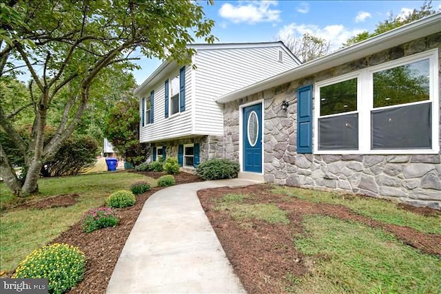 view of front facade featuring stone siding and a front yard